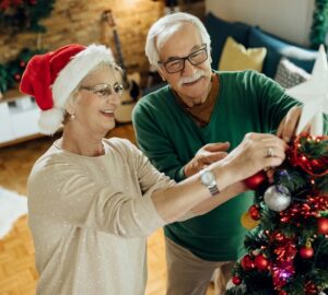 Happy mature couple preparing for Christmas and decorating the t