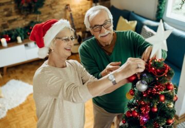 Happy mature couple preparing for Christmas and decorating the t