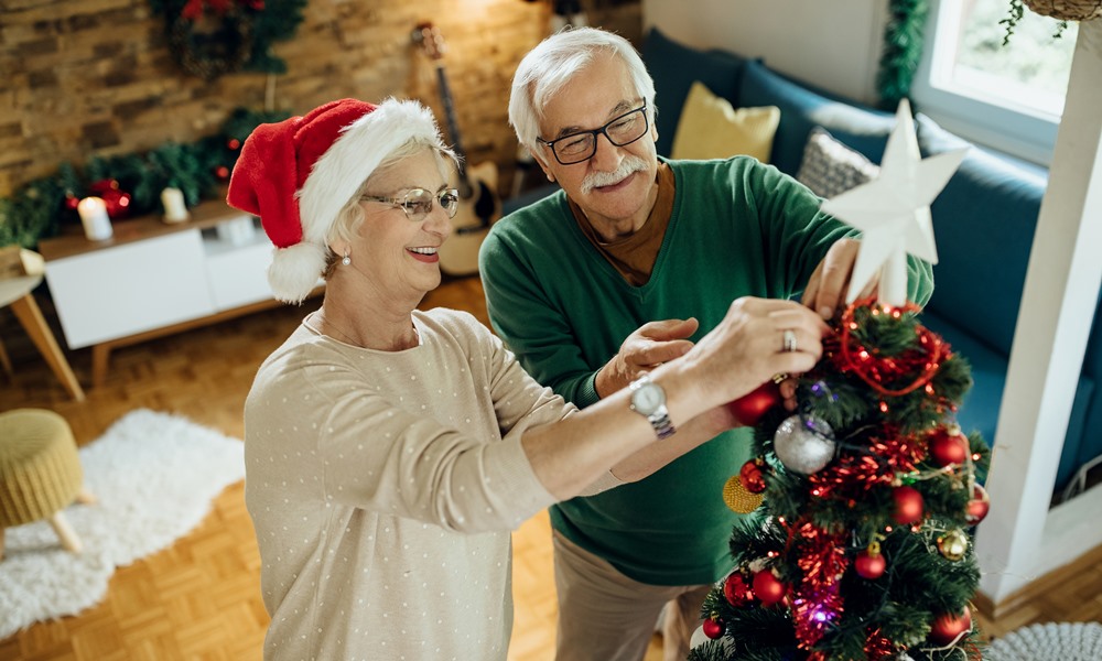 Happy mature couple preparing for Christmas and decorating the t